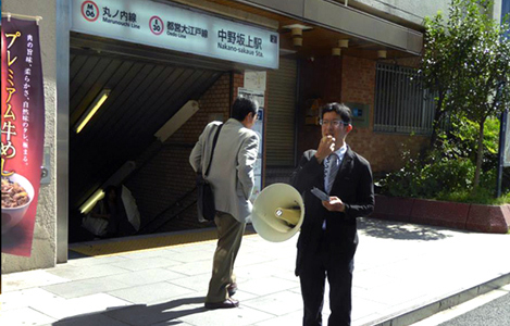 石坂わたるの活動：　中野坂上駅での『たつのこ通信』の配布と区政の報告の様子
